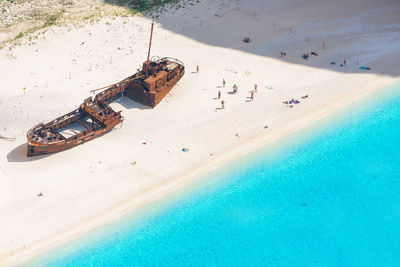 High angle view of shipwreck and people at beach