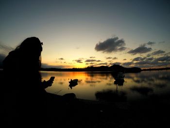 Silhouette of boat in sea at sunset