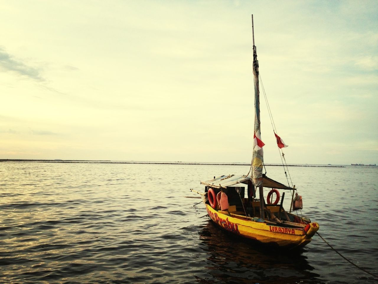 nautical vessel, water, transportation, sea, waterfront, boat, mode of transport, sailboat, sky, mast, sailing, rippled, nature, tranquility, tranquil scene, scenics, cloud - sky, flag, travel, beauty in nature