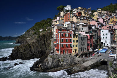 Buildings by sea against sky in city