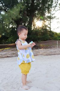 Side view of cute girl standing on sand at beach