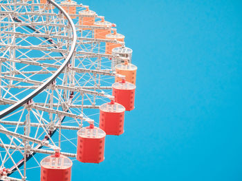 Low angle view of ferris wheel against blue sky