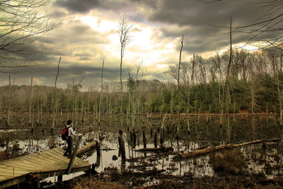 Scenic view of calm lake against cloudy sky