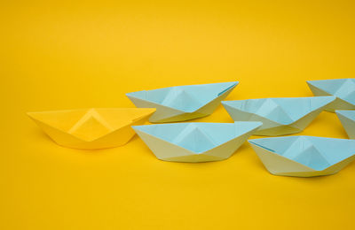 High angle view of paper boats against yellow background