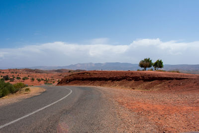 Road amidst desert against sky