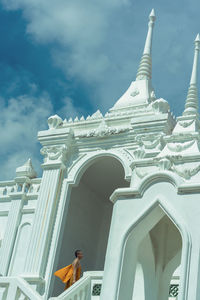 Low angle view of monk standing in temple during sunny day