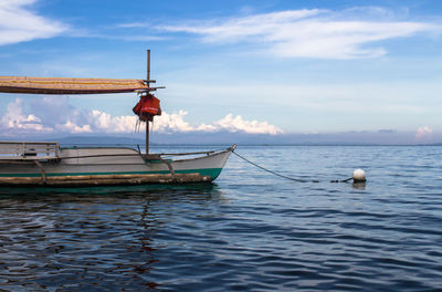 Boat moored on sea against sky