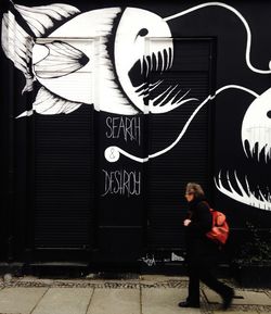 Woman standing by wall