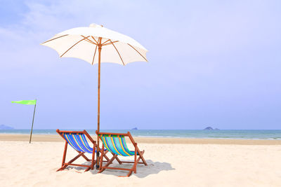 Lifeguard chair on beach against sky