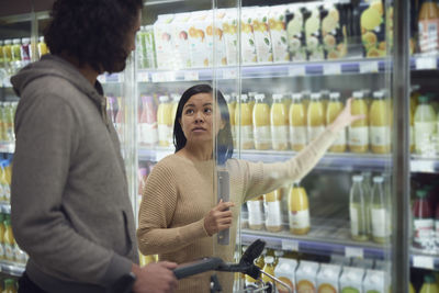 Couple standing in supermarket and talking while shopping