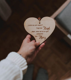 Midsection of woman holding heart shape with text