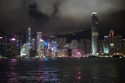 Illuminated buildings in city against sky at night