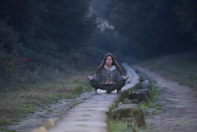 Woman sitting on mountain road
