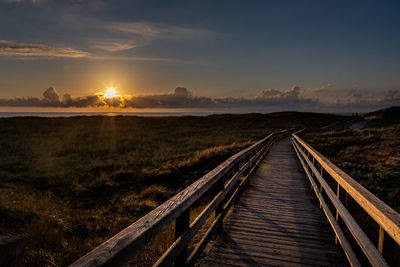 Railroad tracks against sky during sunset