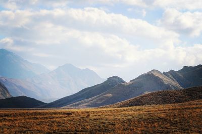 Scenic view of mountains against cloudy sky