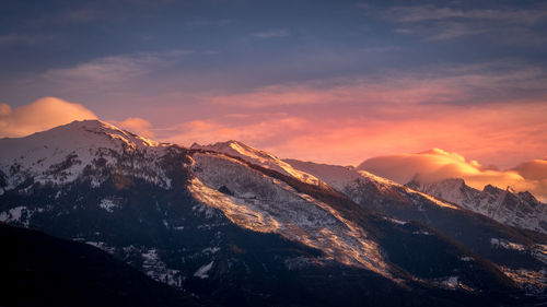 Scenic view of snowcapped mountains against sky during sunset