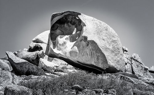Low angle view of rock formation on land against sky