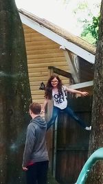 Full length of happy boy standing against built structure