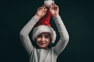Portrait of a caucasian girl in a santa claus hat with cheerful emotions