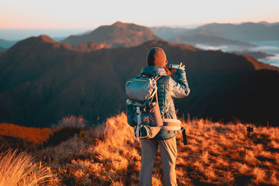 Rear view of person looking at mountain range