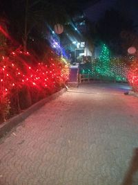 Illuminated christmas lights on street at night