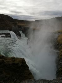 Scenic view of waterfall against sky