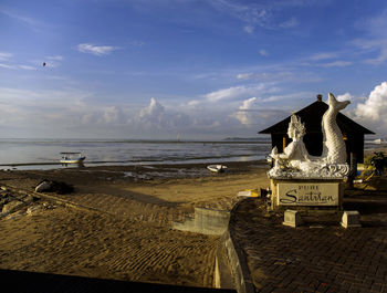 Text on beach against sky