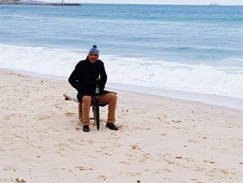 Full length of man sitting on beach