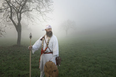 Man standing on field against trees