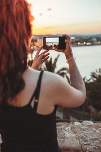 Rear view of woman photographing