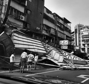 People walking on road along buildings