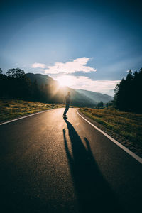 Man riding bicycle on road against sky