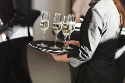 Midsection of waitress serving drinks