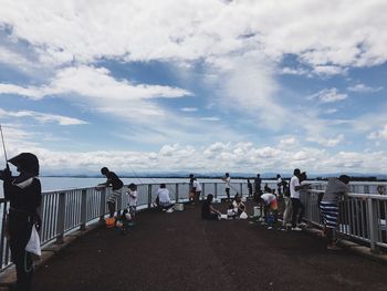 People at beach against sky