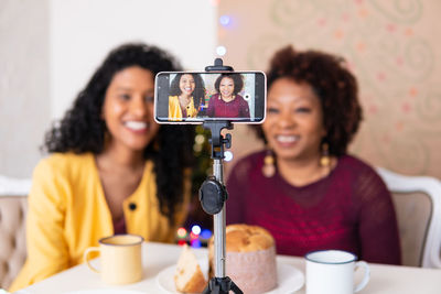 Smiling women blogging at home