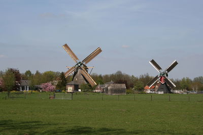 Traditional windmill on field against sky