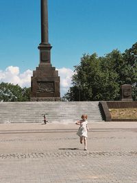 Rear view of girl standing by fountain