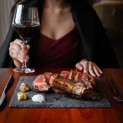 Midsection of woman having food on table