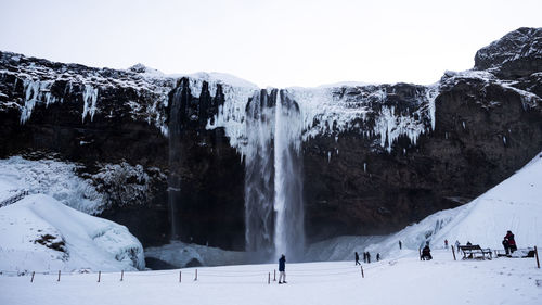 Panoramic view of people on snow covered landscape