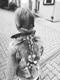 Rear view of girl holding umbrella on street