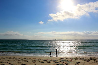 Silhouette siblings at beach