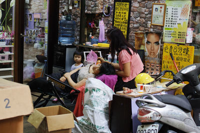 Rear view of people standing at market stall