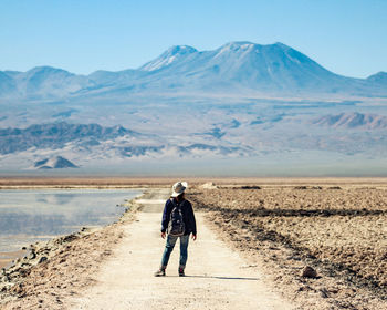 Full length rear view of man on arid landscape