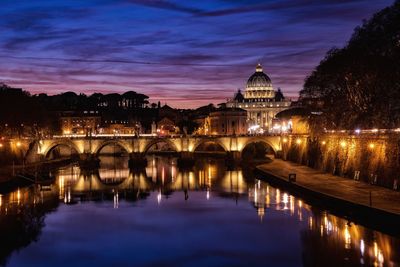 Illuminated bridge over river at night