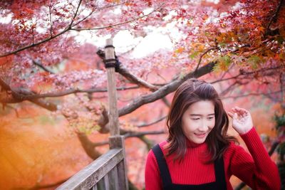 Portrait of smiling young woman with autumn leaves