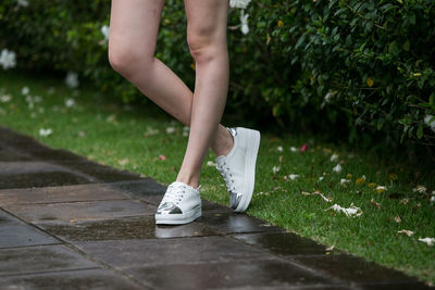 Low section of woman wearing shoes while standing outdoors