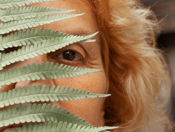 Close-up portrait of senior woman by ferns