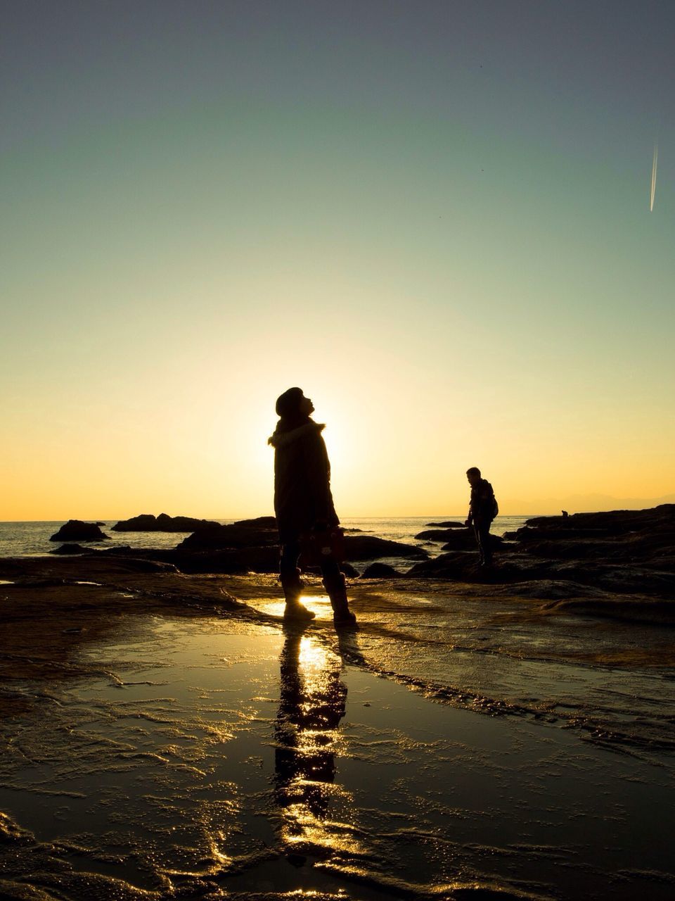 sunset, sea, water, silhouette, beach, horizon over water, clear sky, shore, leisure activity, full length, lifestyles, standing, men, copy space, scenics, orange color, tranquility, tranquil scene, beauty in nature