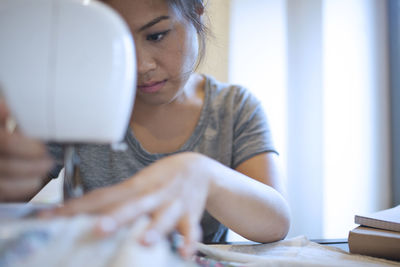 Close-up of woman sewing clothes 