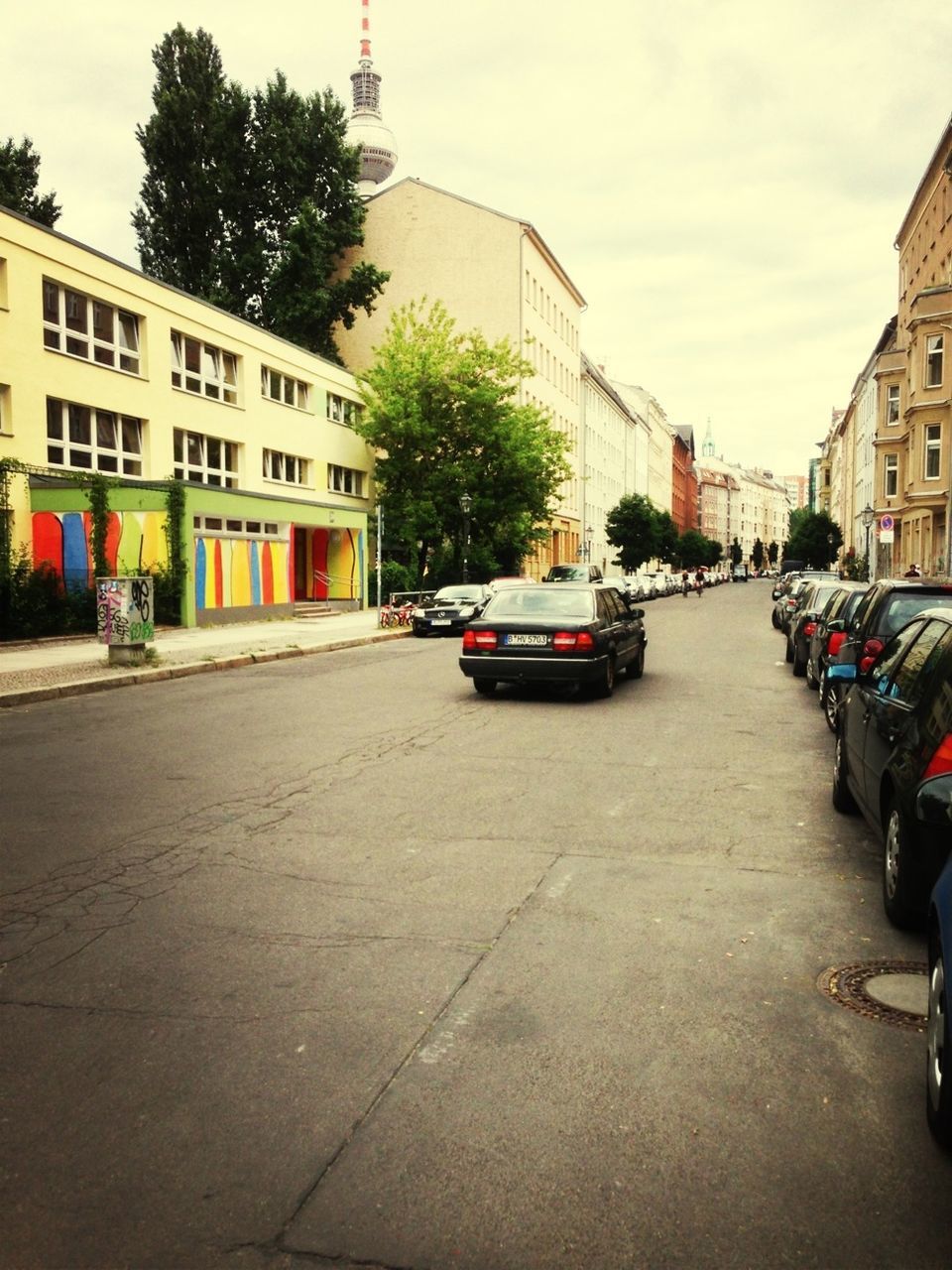 building exterior, architecture, transportation, built structure, car, street, land vehicle, city, mode of transport, road, city street, city life, incidental people, the way forward, building, sky, residential structure, residential building, traffic, parking